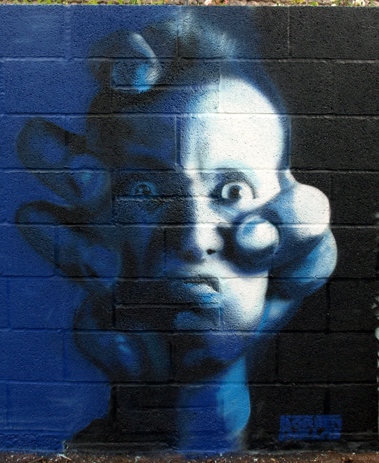Painting of man's head being held by a big hand